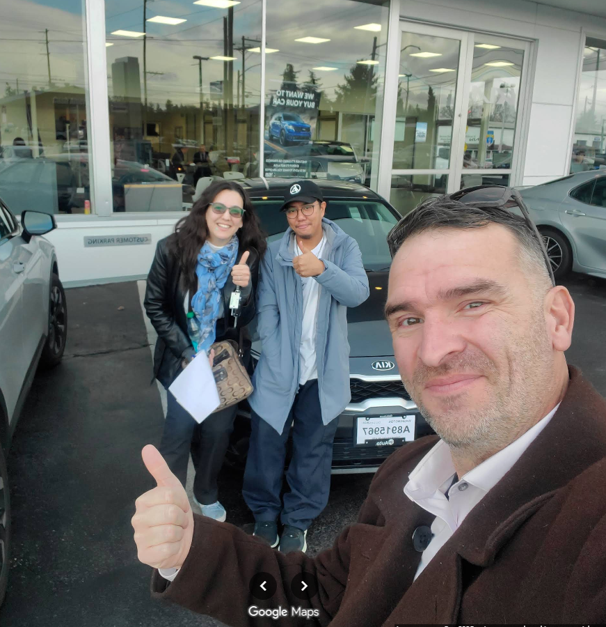 Crystal Flud with Ian celebrating her new car purchase — red car delivery day selfie