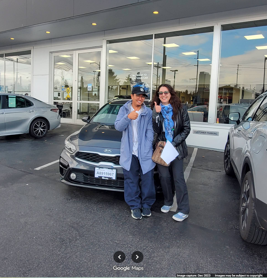 Rachel Goon and Ian posing with the grey KIA after completing the purchase